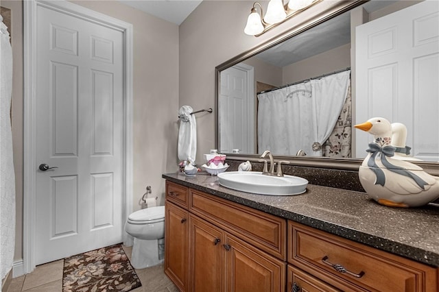 bathroom with tile patterned flooring, vanity, and toilet