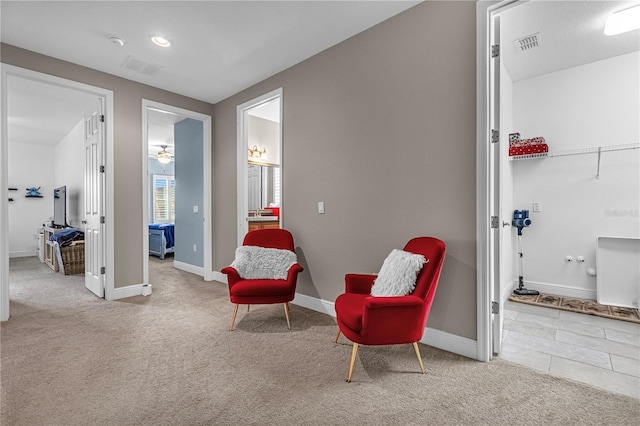 living area with carpet flooring, visible vents, and baseboards