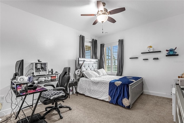 carpeted bedroom with ceiling fan and baseboards