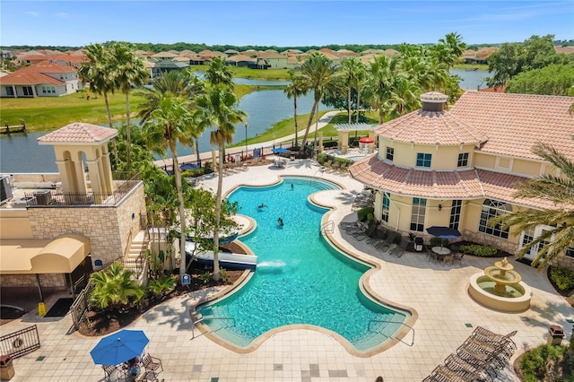 community pool featuring a water view, a patio area, and a residential view