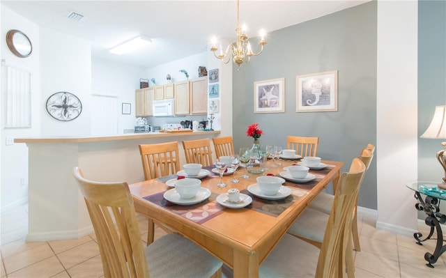 tiled dining room with a notable chandelier