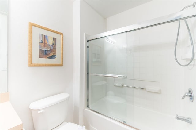 bathroom with combined bath / shower with glass door and toilet