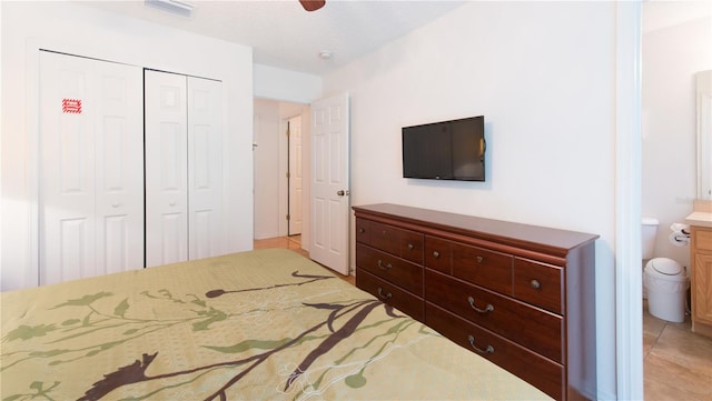 tiled bedroom with connected bathroom, ceiling fan, a closet, and a textured ceiling