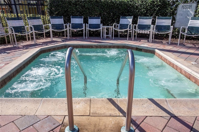 view of swimming pool featuring a hot tub