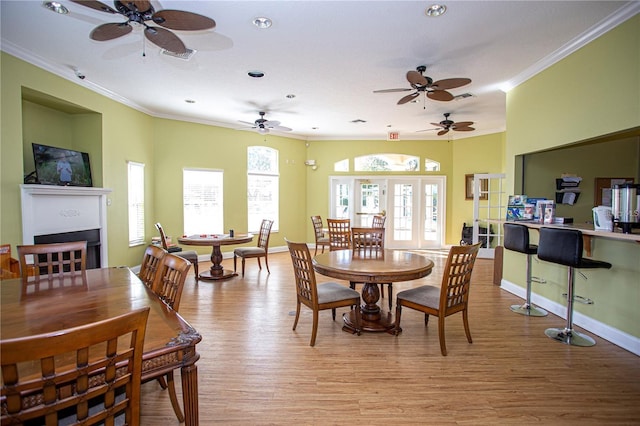 dining area featuring french doors, light hardwood / wood-style floors, and ornamental molding