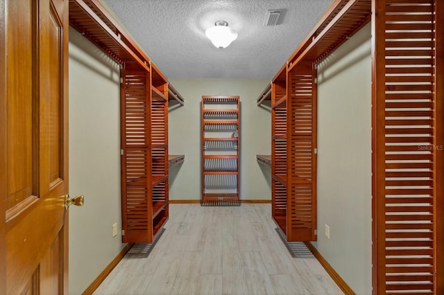 spacious closet featuring light hardwood / wood-style floors