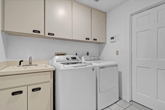 washroom featuring independent washer and dryer, cabinets, light tile patterned floors, and sink