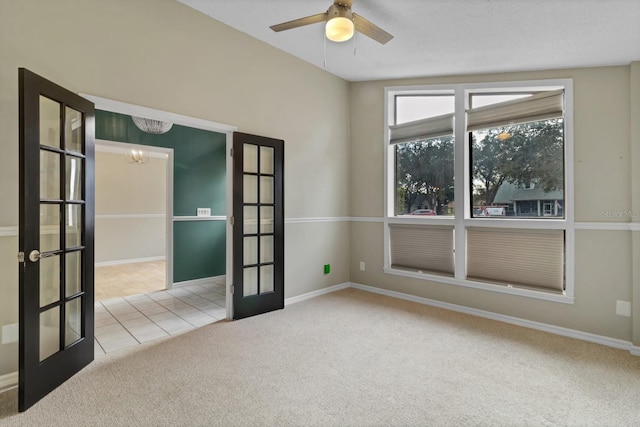 empty room with ceiling fan with notable chandelier, french doors, and light colored carpet