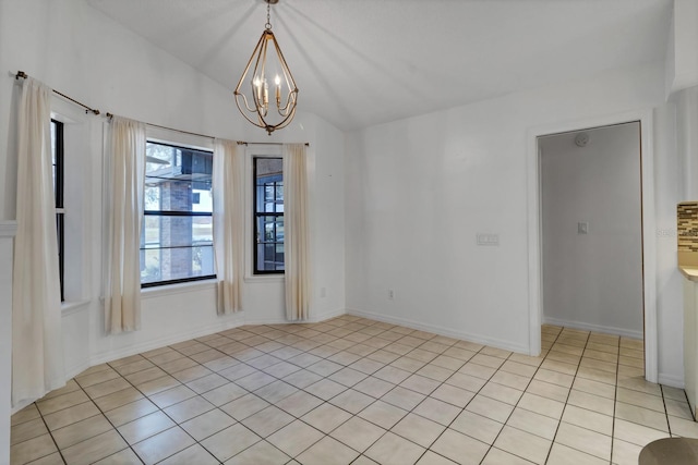 tiled spare room featuring an inviting chandelier and vaulted ceiling