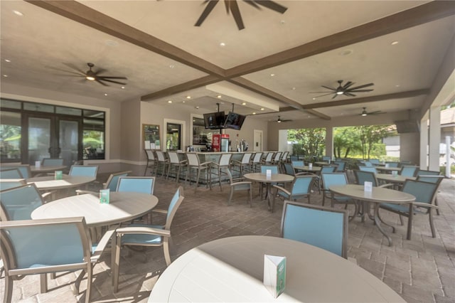 dining area featuring beamed ceiling and ceiling fan