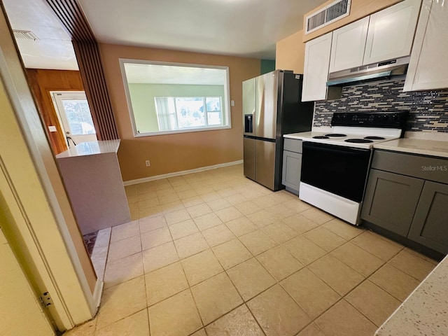 kitchen featuring tasteful backsplash, white cabinets, stainless steel fridge, electric range oven, and a healthy amount of sunlight