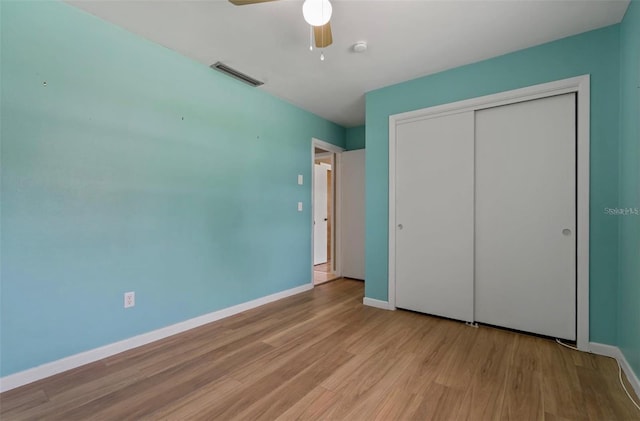 unfurnished bedroom featuring ceiling fan, light hardwood / wood-style floors, and a closet