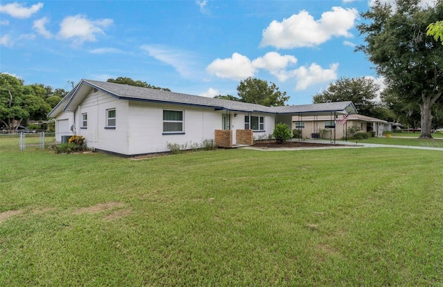 ranch-style house featuring a front lawn and a carport