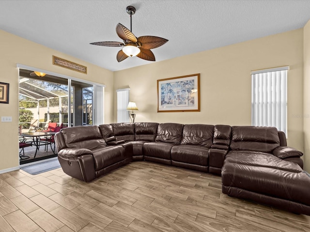 living room with a textured ceiling and ceiling fan