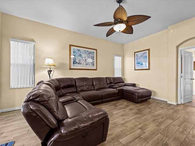 living room featuring a textured ceiling and ceiling fan