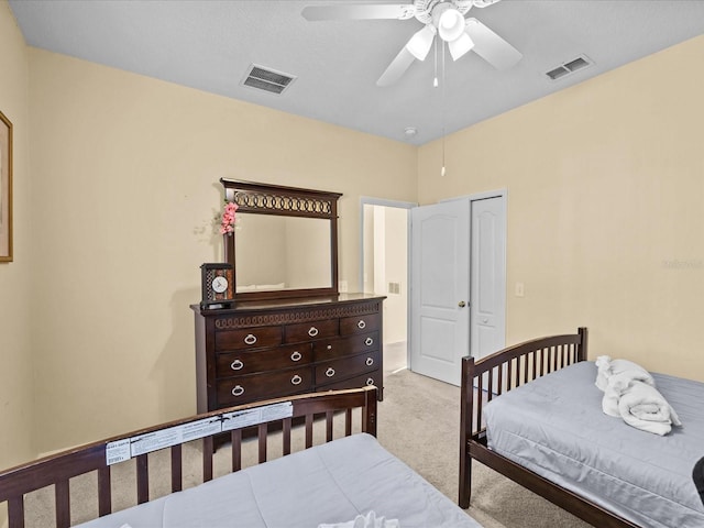 bedroom featuring a closet, light carpet, and ceiling fan