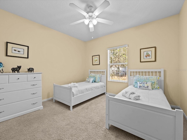 carpeted bedroom with ceiling fan and a textured ceiling