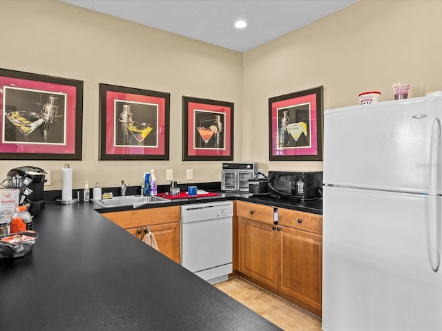 kitchen featuring white appliances, light tile patterned floors, and sink