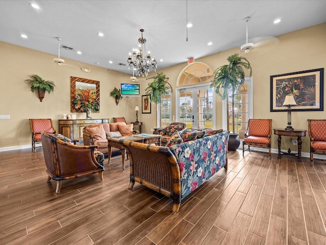 living room with ceiling fan with notable chandelier and french doors