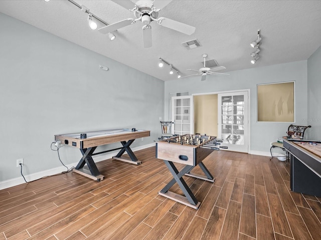 recreation room with ceiling fan and a textured ceiling