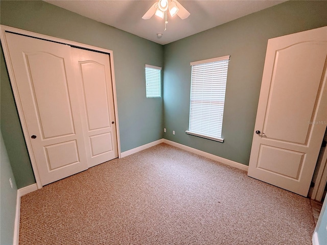 unfurnished bedroom with ceiling fan, light colored carpet, and a closet