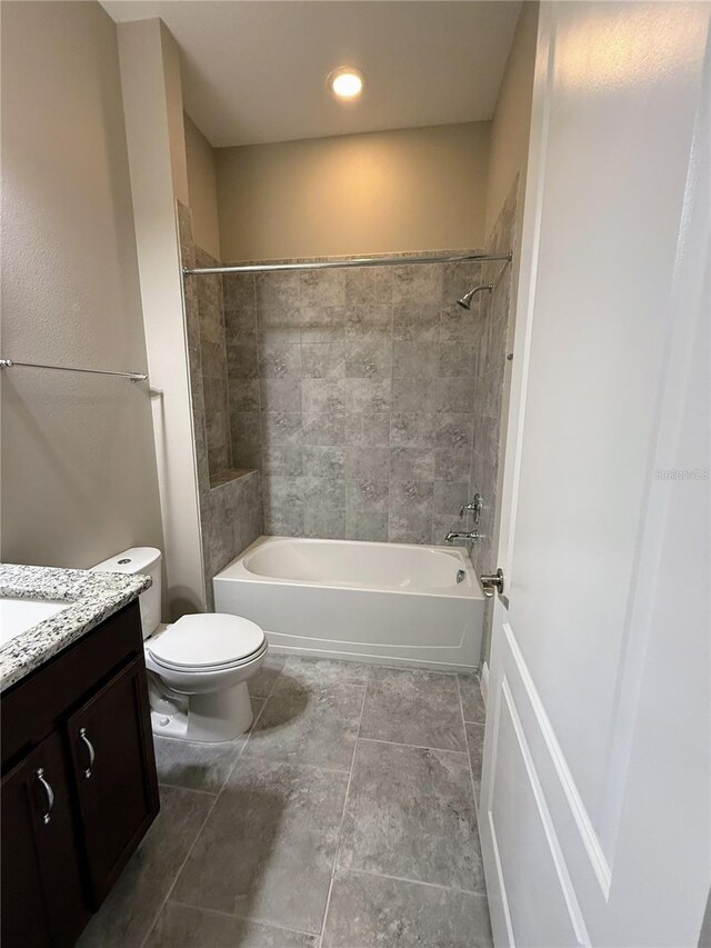 full bathroom with toilet, tiled shower / bath, and vanity