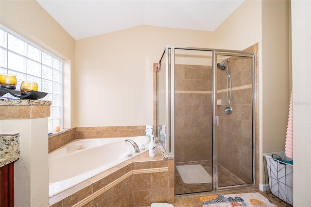 bathroom featuring plus walk in shower, vanity, tile patterned flooring, and lofted ceiling