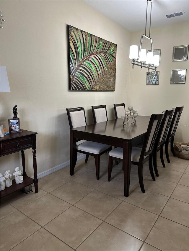 tiled dining area featuring a chandelier