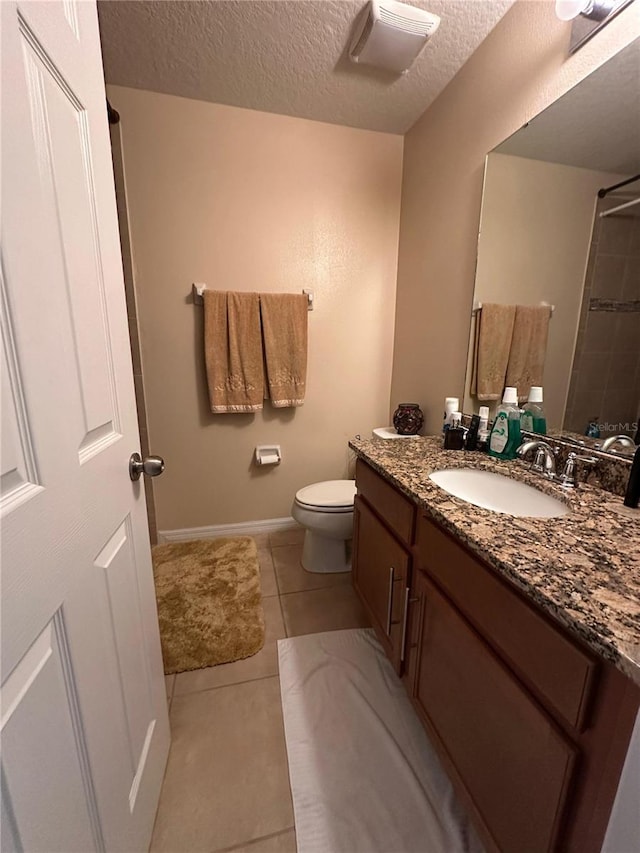 bathroom with walk in shower, a textured ceiling, vanity, tile patterned flooring, and toilet