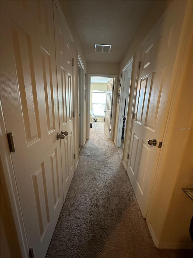 hallway featuring light colored carpet