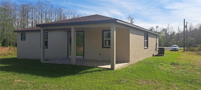 rear view of house featuring a patio area, central AC unit, and a lawn