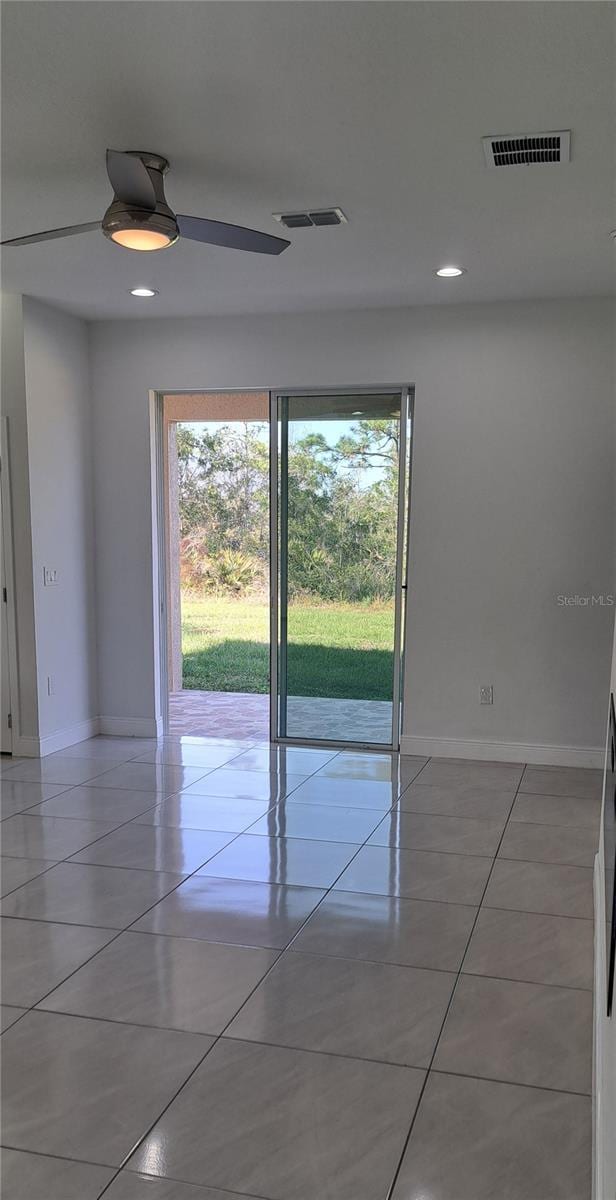 spare room featuring light tile patterned floors and ceiling fan