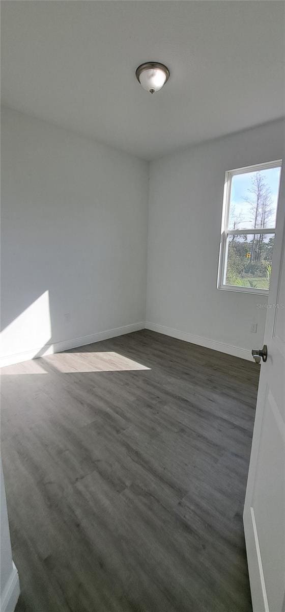 unfurnished room featuring dark hardwood / wood-style flooring