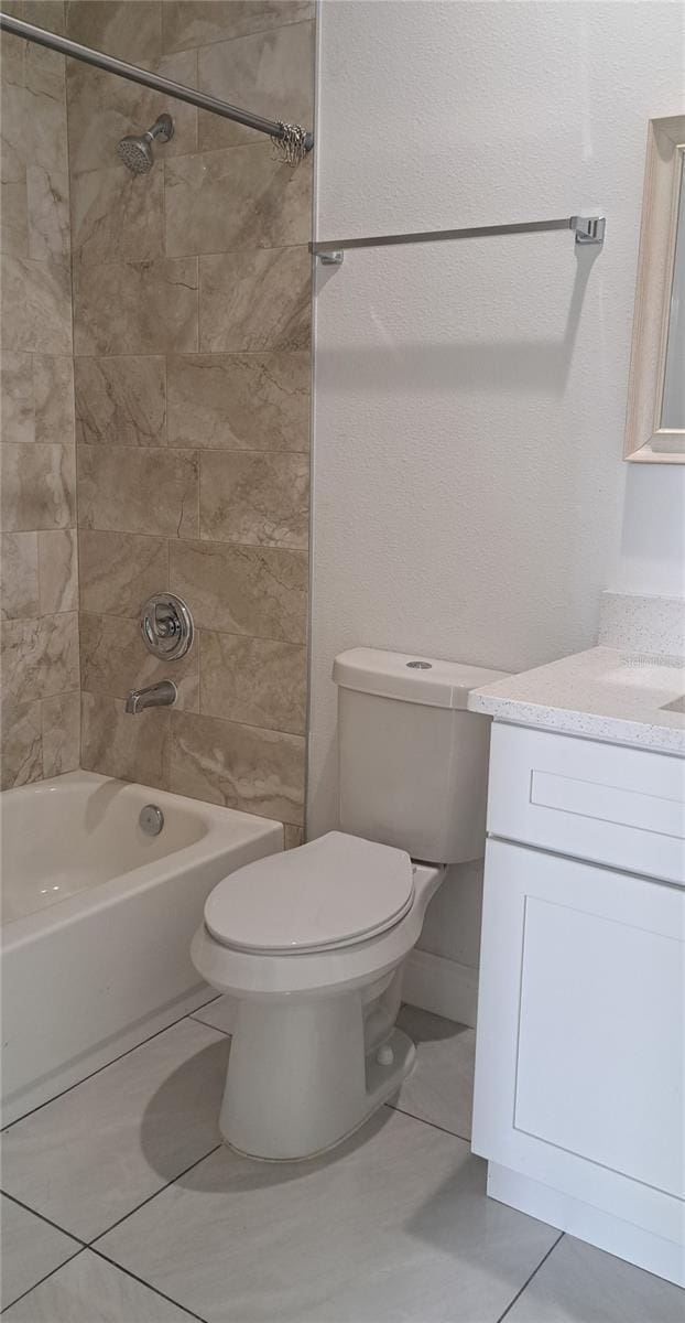 full bathroom featuring vanity, toilet, tiled shower / bath combo, and tile patterned flooring