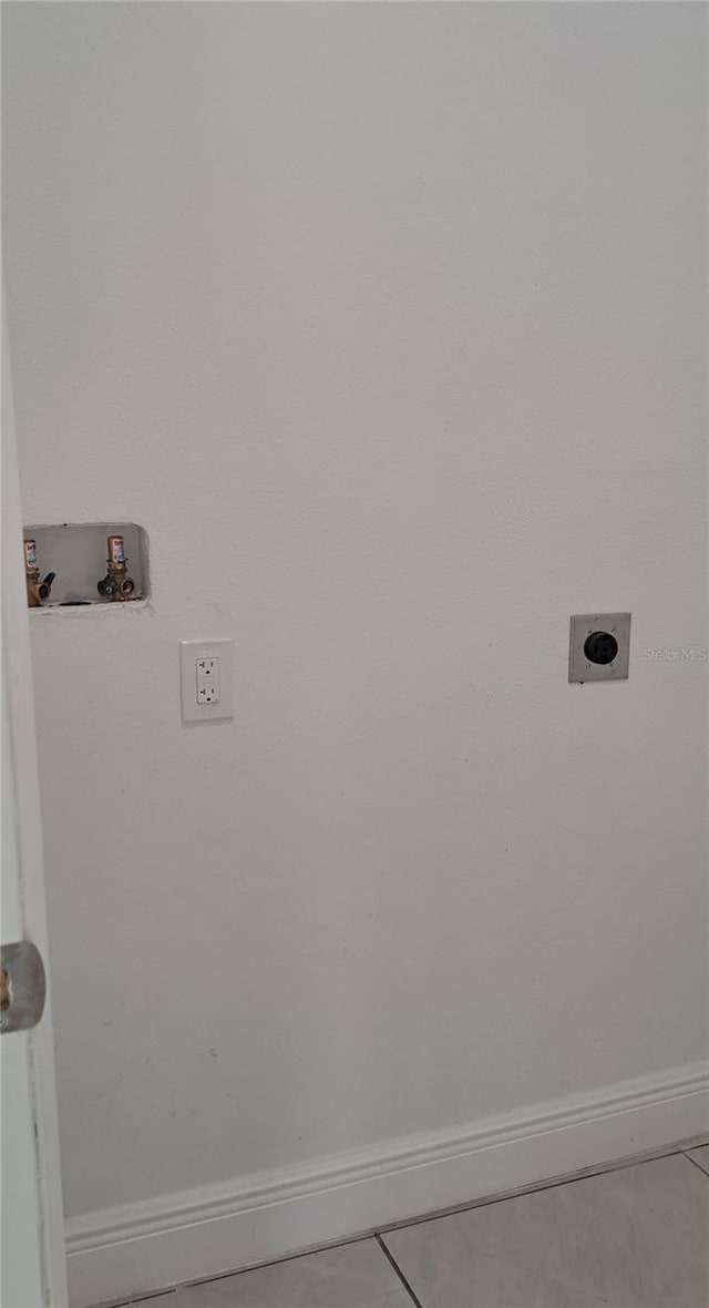 clothes washing area featuring hookup for an electric dryer, hookup for a washing machine, and light tile patterned floors