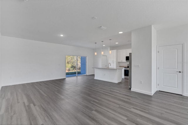 unfurnished living room featuring dark hardwood / wood-style flooring and sink