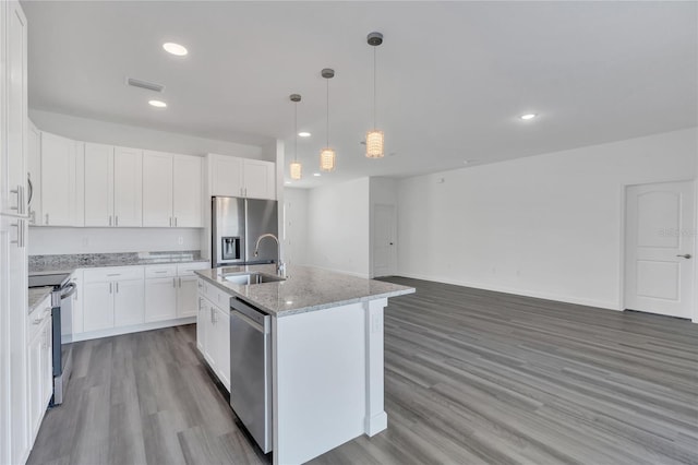 kitchen with sink, white cabinetry, stainless steel appliances, and an island with sink