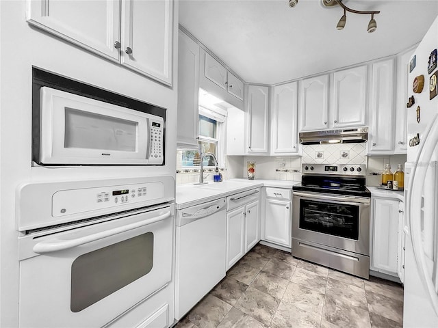 kitchen featuring tasteful backsplash, sink, white cabinets, and white appliances