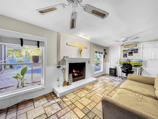 living room featuring a textured ceiling and ceiling fan