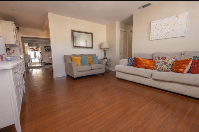 living room featuring dark hardwood / wood-style flooring and a notable chandelier