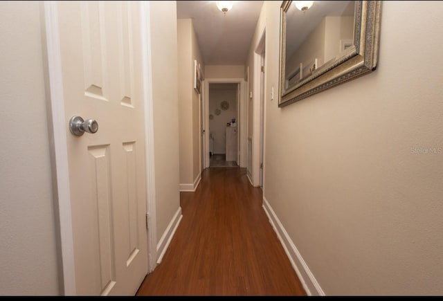 corridor with dark hardwood / wood-style flooring