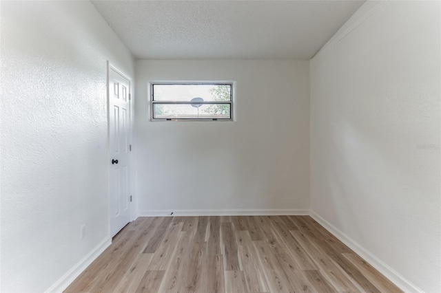 spare room with light hardwood / wood-style floors and a textured ceiling