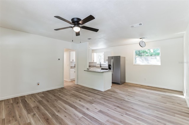 unfurnished living room with ceiling fan and light hardwood / wood-style flooring