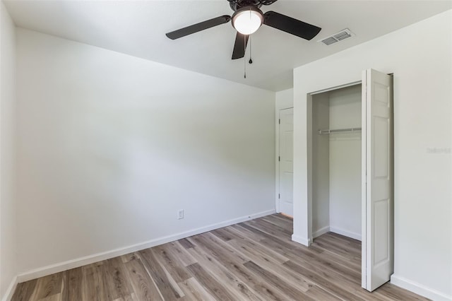 unfurnished bedroom featuring ceiling fan, light hardwood / wood-style flooring, and a closet