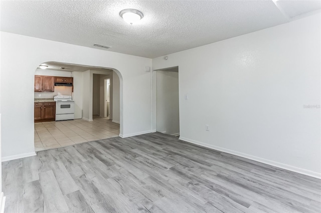 unfurnished living room featuring a textured ceiling and light wood-type flooring