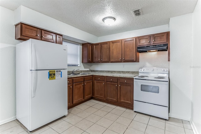 kitchen with a textured ceiling, white appliances, and sink