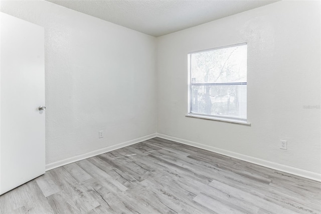 empty room featuring light hardwood / wood-style floors and a textured ceiling