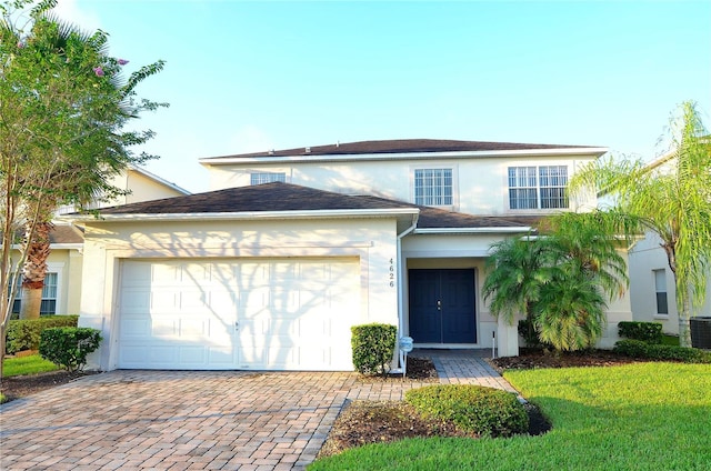 view of front of home featuring central AC unit, a garage, and a front lawn