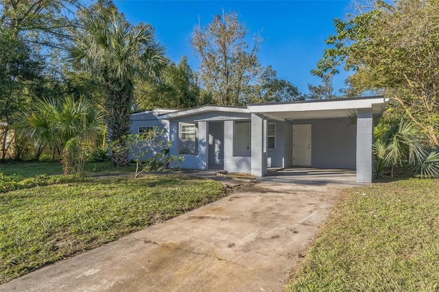 view of front of home with a front yard and a carport