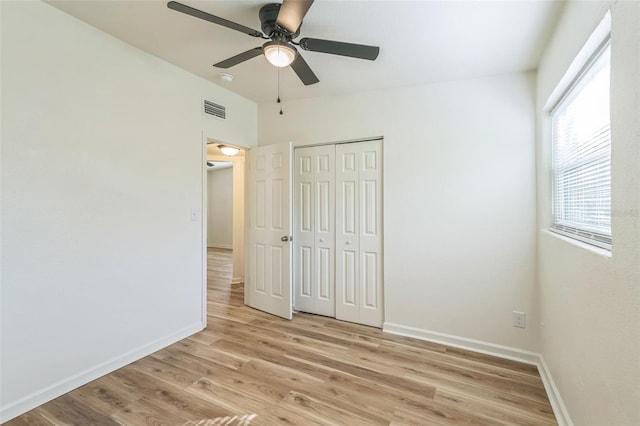 unfurnished bedroom featuring ceiling fan, light wood-type flooring, and a closet